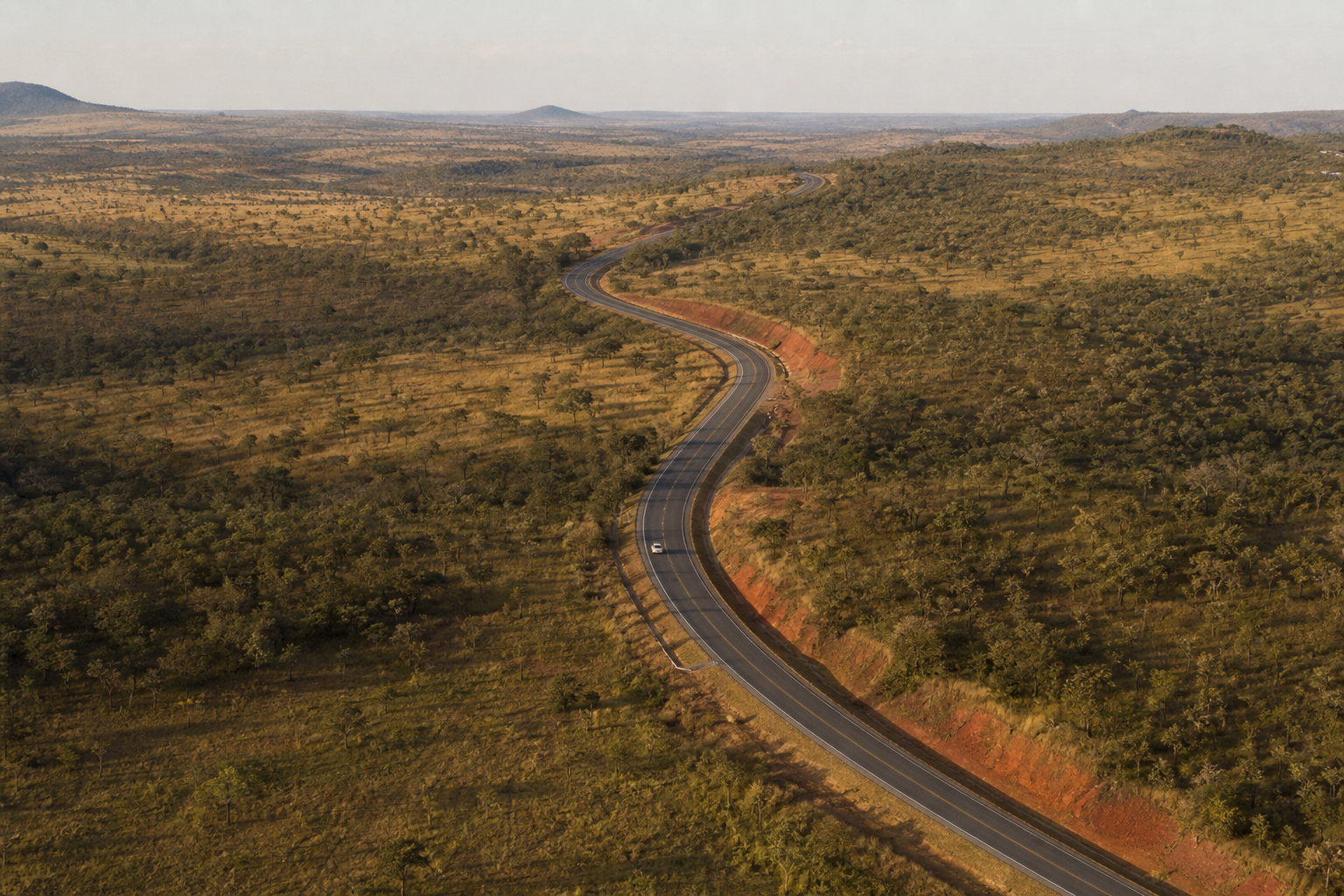 Vista aérea de uma rodovia sinuosa atravessando vegetação de Cerrado em Goiás